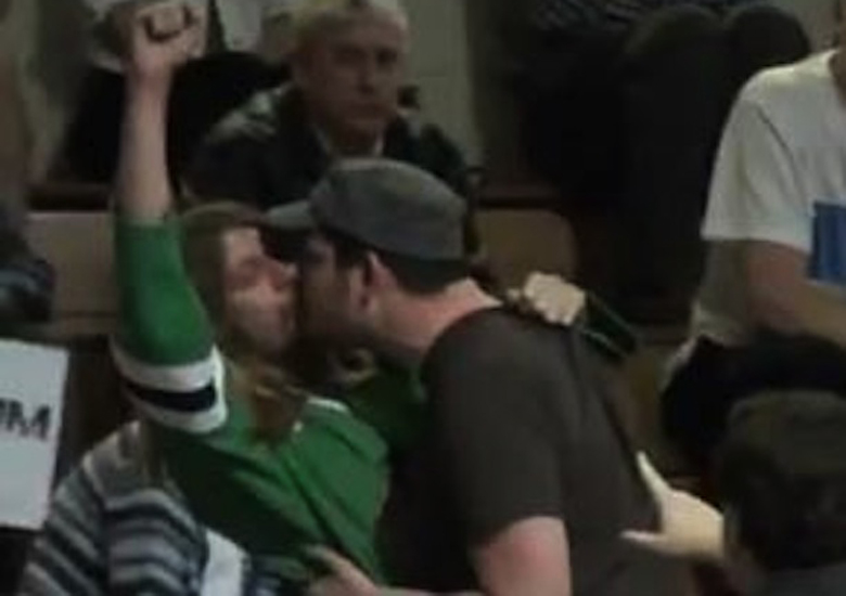 Timothy Tross e Ben Clifford fazem sinal de protesto ao se beijarem em comcio de Rick Santorum.