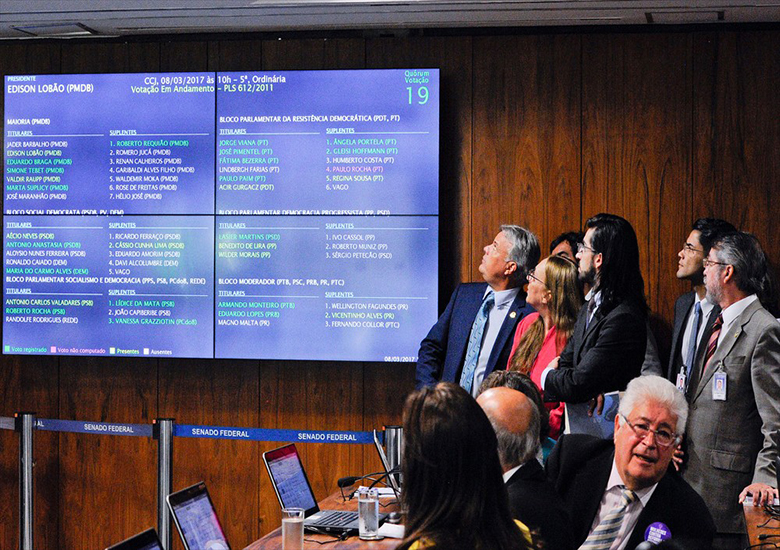 Senadores observam painel durante sess�o da Comiss�o de Constitui��o e Justi�a que aprovou a uni�o est�vel entre pessoas do mesmo sexo; em primeiro plano, o relator do projeto, senador Roberto Requi�o (PMDB-PR).